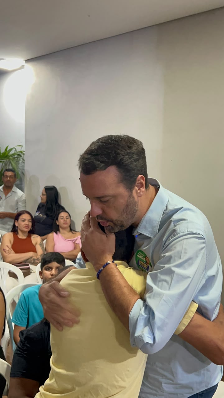 Rodrigo Tavares abraçando um apoiador em reunião de campanha